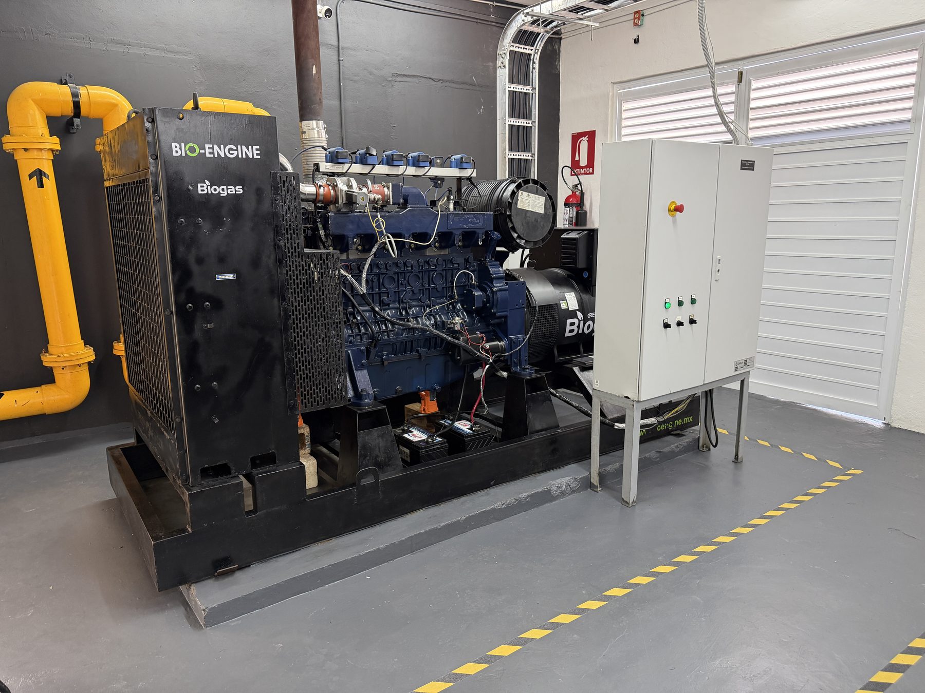 Motogenerador Bio-Engine con su línea de biogás y su tablero, en sala.